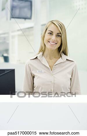 Businesswoman standing behind counter, smiling at camera, portrait View Large Photo Image Stock Photography - Businesswoman standing behind counter, smiling at camera, portrait. Fotosearch