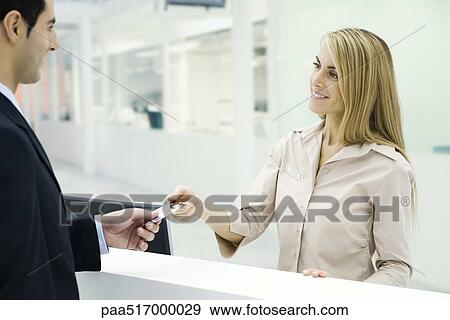 Stock Photo - Customer handing credit card to customer service representative. Fotosearch