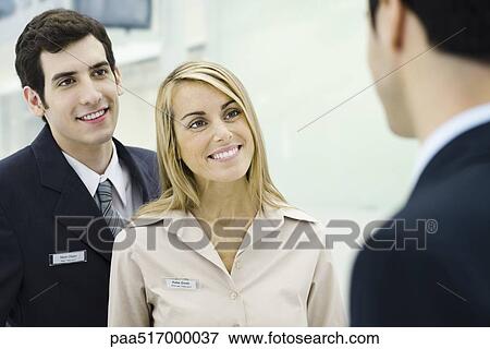 Customer service representatives chatting with associate, smiling View Large Photo Image Stock Photo - Customer service representatives chatting with associate, smiling. Fotosearch