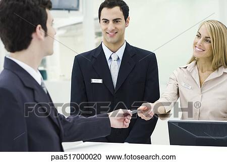 Man giving credit card to smiling customer service representatives View Large Photo Image Stock Image - Man giving credit card to smiling customer service representatives . Fotosearch