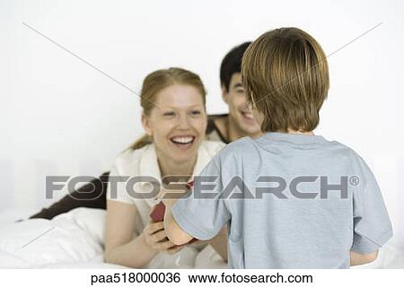 Boy giving mother gift, rear view View Large Photo Image Stock Photograph - Boy giving mother gift, rear view. Fotosearch