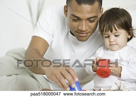 Father and toddler daughter playing with toys together View Large Photo Image Stock Photo - Father and toddler daughter playing with toys together. Fotosearch
