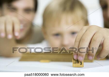 Little boy holding game piece, focus on foreground View Large Photo Image Stock Image - Little boy holding game piece, focus on foreground. Fotosearch