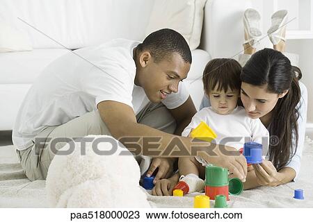 Parents and toddler girl playing with building blocks on floor View Large Photo Image Stock Image - Parents and toddler girl playing with building blocks on floor. Fotosearch