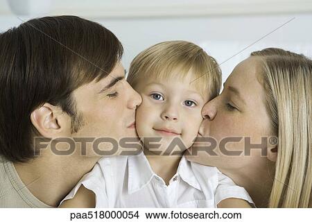 Parents kissing little boy's cheeks, boy smiling at camera View Large Photo Image Picture - Parents kissing little boy's cheeks, boy smiling at camera. Fotosearch