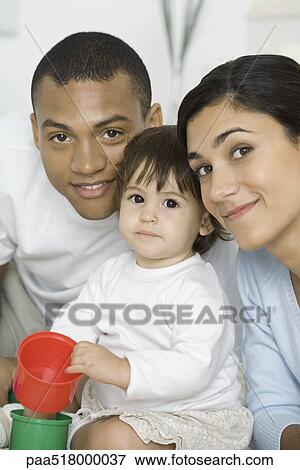 Parents posing with toddler daughter, girl holding plastic toys View Large Photo Image Stock Photo - Parents posing with toddler daughter, girl holding plastic toys. Fotosearch