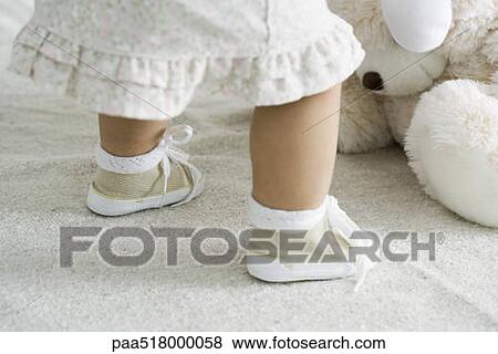 Toddler girl bending over stuffed toy, cropped view View Large Photo Image Stock Photo - Toddler girl bending over stuffed toy, cropped view. Fotosearch