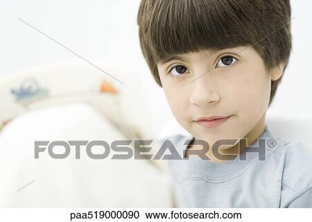 Boy holding book, looking at camera, close-up View Large Photo Image Stock Image - Boy holding book, looking at camera, close-up. Fotosearch