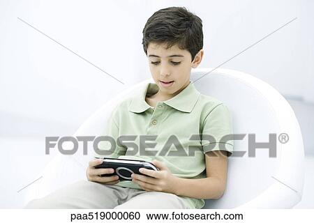 Boy playing handheld video game View Large Photo Image Stock Image - Boy playing handheld video game. Fotosearch