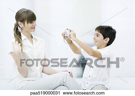 Boy taking photo of young woman, side view View Large Photo Image Stock Image - Boy taking photo of young woman, side view. Fotosearch