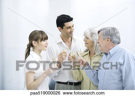 Couple standing with senior parents, all holding champagne flutes View Large Photo Image Stock Photograph - Couple standing with senior parents, all holding champagne flutes. Fotosearch