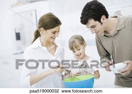 Family cooking together in kitchen View Large Photo Image Stock Image - Family cooking together in kitchen. Fotosearch