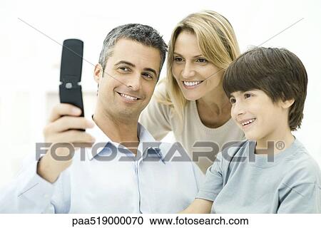 Family looking at cell phone together, smiling View Large Photo Image Stock Image - Family looking at cell phone together, smiling. Fotosearch