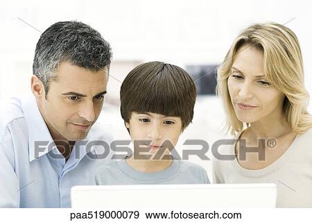 Stock Photo - Family looking at laptop computer together, close-up. Fotosearch