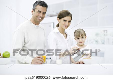 Family preparing breakfast in kitchen, smiling at camera View Large Photo Image Stock Photography - Family preparing breakfast in kitchen, smiling at camera. Fotosearch