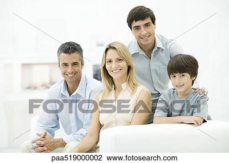 Family sitting together on couch, smiling, portrait View Large Photo Image Stock Image - Family sitting together on couch, smiling, portrait. Fotosearch