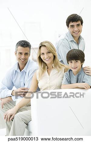Family sitting together on sofa, smiling, portrait View Large Photo Image Stock Image - Family sitting together on sofa, smiling, portrait. Fotosearch
