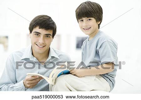 Father and son reading book together, smiling at camera View Large Photo Image Stock Image - Father and son reading book together, smiling at camera. Fotosearch