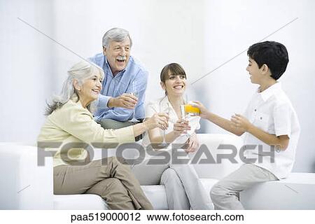 Multi-generation family clinking glasses, smiling at each other View Large Photo Image Stock Image - Multi-generation family clinking glasses, smiling at each other. Fotosearch