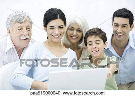 Multi-generation family gathered around laptop computer, smiling View Large Photo Image Stock Image - Multi-generation family gathered around laptop computer, smiling. Fotosearch