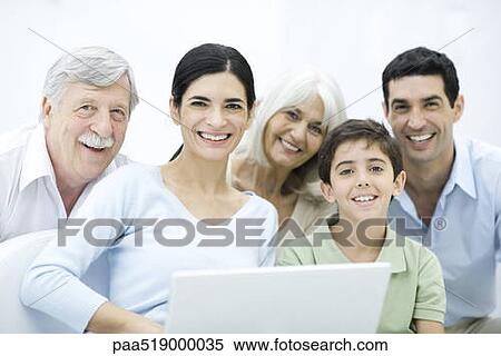 Multi-generation family gathered around laptop computer, smiling at camera View Large Photo Image Stock Photography - Multi-generation family gathered around laptop computer, smiling at camera. Fotosearch