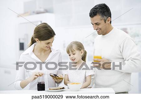 Parents and young daughter preparing breakfast in kitchen View Large Photo Image Stock Photo - Parents and young daughter preparing breakfast in kitchen. Fotosearch