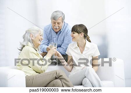 Senior parents and adult daughter clinking champagne glasses, smiling View Large Photo Image Stock Image - Senior parents and adult daughter clinking champagne glasses, smiling. Fotosearch