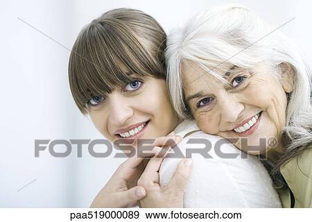 Senior woman leaning against adult daughter's back, both smiling at camera and holding hands View Large Photo Image Stock Photo - Senior woman leaning against adult daughter's back, both smiling at camera and holding hands. Fotosearch