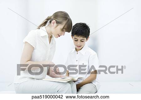 Young woman and boy reading book together View Large Photo Image Stock Image - Young woman and boy reading book together. Fotosearch
