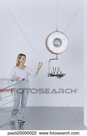 Woman standing with shopping cart, placing cans on scale View Large Photo Image Stock Image - Woman standing with shopping cart, placing cans on scale. Fotosearch