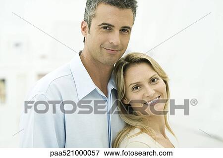 Stock Photo - Couple smiling at camera, woman leaning against man, portrait. Fotosearch