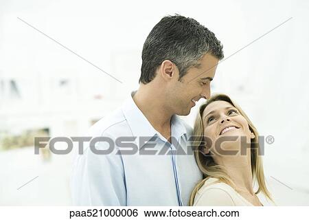 Couple smiling at each other, woman leaning against man View Large Photo Image Stock Photograph - Couple smiling at each other, woman leaning against man. Fotosearch