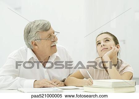 Grandfather helping granddaughter with homework View Large Photo Image Stock Photography - Grandfather helping granddaughter with homework. Fotosearch