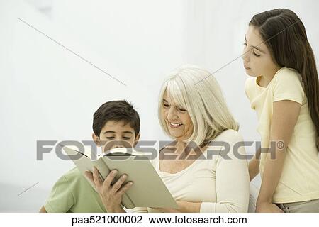 Grandmother and grandchildren reading book together View Large Photo Image Stock Image - Grandmother and grandchildren reading book together. Fotosearch