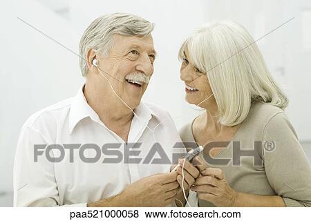 Stock Photo - Senior couple listening to MP3 player together. Fotosearch
