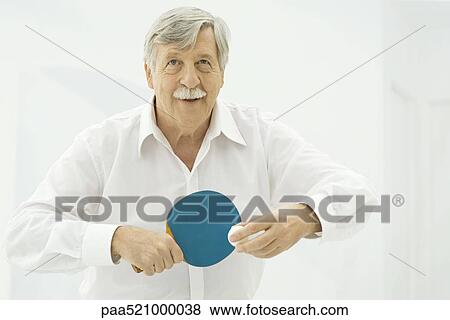 Stock Photo - Senior man playing table tennis. Fotosearch