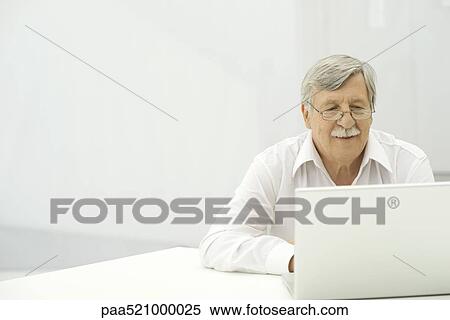 Stock Photography - Senior man using laptop computer. Fotosearch