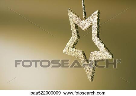 Stock Photo - Golden star shaped Christmas tree ornament, upside down. Fotosearch