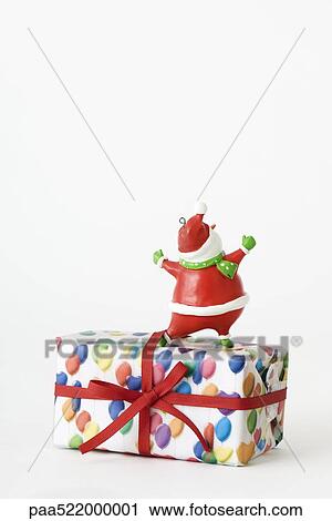 Santa Claus figurine standing on top of Christmas present, rear view View Large Photo Image Stock Image - Santa Claus figurine standing on top of Christmas present, rear view. Fotosearch