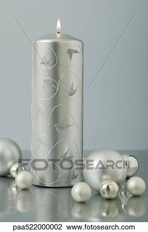 Silver advent candle surrounded by Christmas tree ornaments View Large Photo Image Stock Image - Silver advent candle surrounded by Christmas tree ornaments . Fotosearch