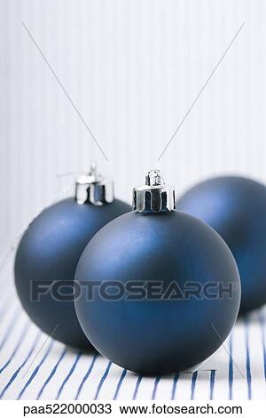 Stock Image - Three blue Christmas tree ornaments. Fotosearch