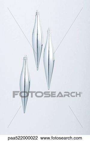 Stock Image - Three silver Christmas tree ornaments. Fotosearch