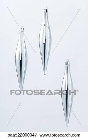 Three silver Christmas tree ornaments suspended against silvery background View Large Photo Image Stock Photo - Three silver Christmas tree ornaments suspended against silvery background. Fotosearch