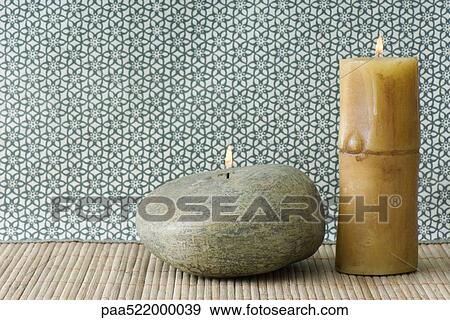 Two candles, one river rock colored and shaped, the other bamboo shaped View Large Photo Image Stock Photo - Two candles, one river rock colored and shaped, the other bamboo shaped. Fotosearch