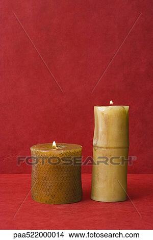 Picture - Two pillar candles, side by side, burning. Fotosearch