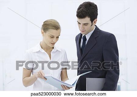 Colleagues looking at document together View Large Photo Image Stock Image - Colleagues looking at document together. Fotosearch