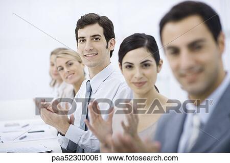 Group of professionals clapping, smiling at camera View Large Photo Image Stock Image - Group of professionals clapping, smiling at camera. Fotosearch