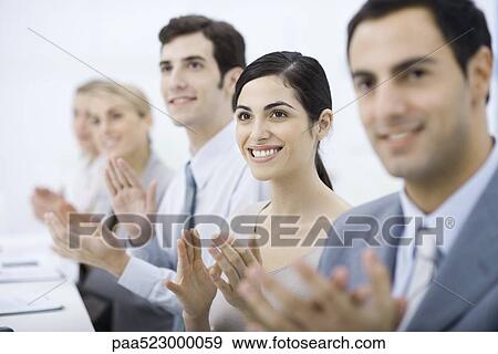 Group of professionals clapping, smiling, focus on one woman View Large Photo Image Stock Photo - Group of professionals clapping, smiling, focus on one woman. Fotosearch