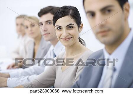 Professionals lined up, smiling at camera, selective focus View Large Photo Image Stock Photo - Professionals lined up, smiling at camera, selective focus. Fotosearch