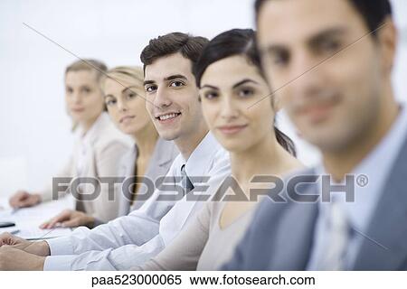 Professionals lined up, smiling at camera, selective focus View Large Photo Image Stock Photography - Professionals lined up, smiling at camera, selective focus. Fotosearch